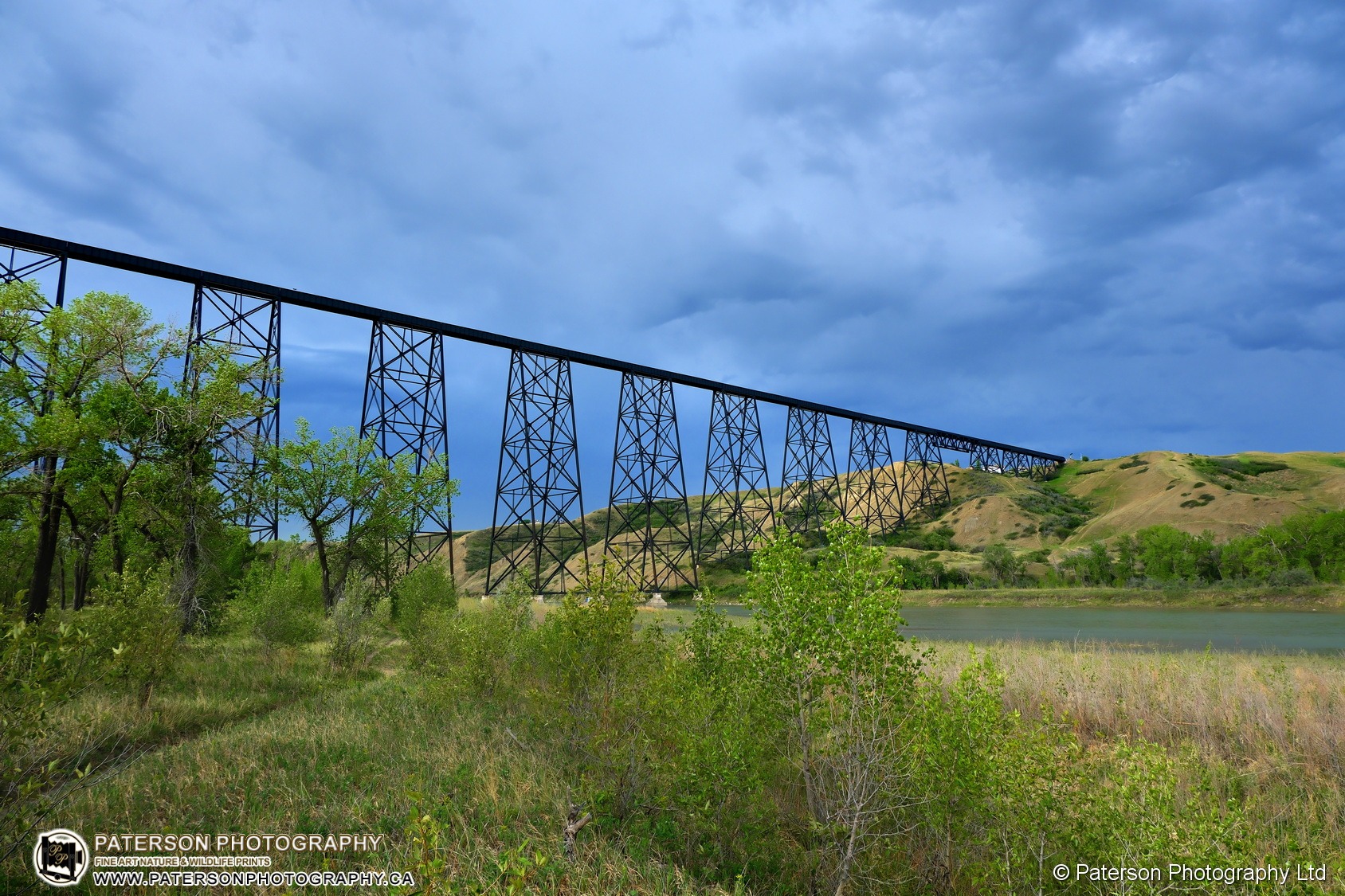 Storm Clouds, rising Oldman river and the Lethbridge Bridge